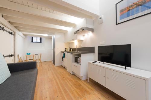 une grande cuisine blanche avec une grande télévision à écran plat dans l'établissement Daurade, à Toulouse