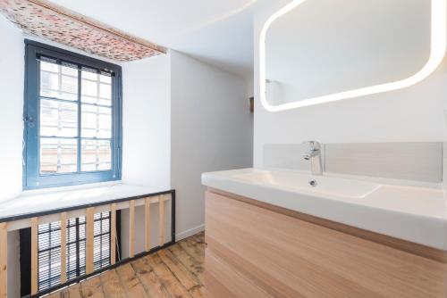 bagno con lavandino e finestra di Daurade a Tolosa