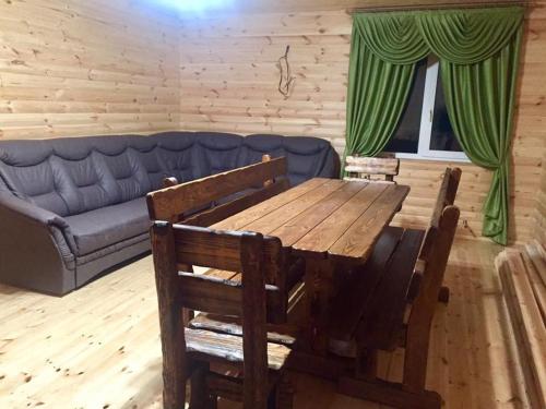 a living room with a wooden table and a couch at Райский Дворик in Pogreby