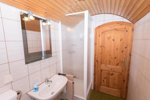 een badkamer met een wastafel en een houten deur bij Ferienhaus Toff in Schiefling am See