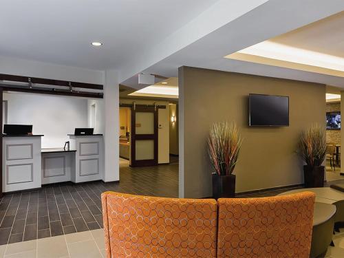 an office lobby with a table and a tv on a wall at Extended Stay America Suites - Rock Hill in Rock Hill