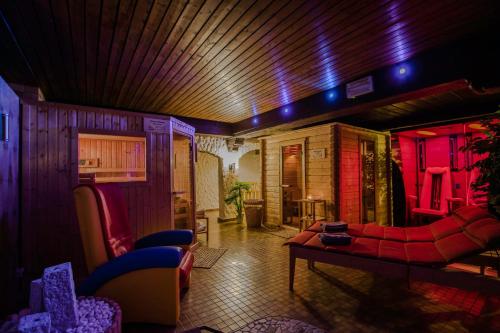 a living room with red furniture and purple lights at Hotel Schneider in Winterberg