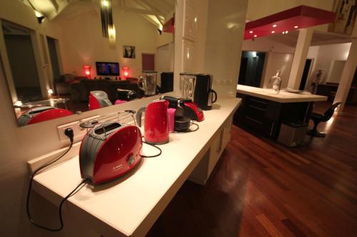 a kitchen with a counter with red appliances on it at Yin & Yang in Sainte-Anne