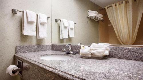 a bathroom with a sink and a mirror and towels at Relax Inn - Batavia in Batavia