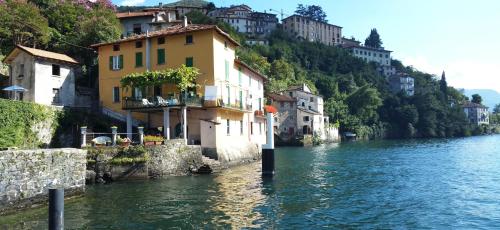 a group of buildings on the side of a river at Gli Ulivi di Nesso in Nesso