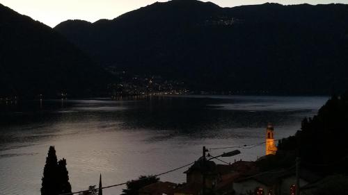 a view of a river with a town and a clock tower at Gli Ulivi di Nesso in Nesso