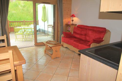 sala de estar con sofá rojo y mesa en At Home en Les Carroz d'Araches
