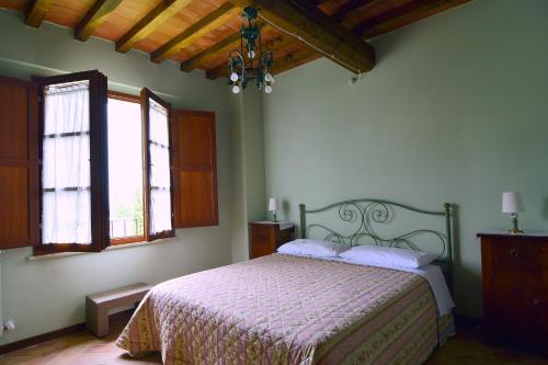 una camera con un letto e due finestre di Casa Mire, San Gimignano a Gambassi