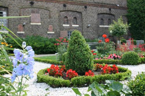 a garden with flowers and plants in front of a building at Bleckmanns Hof in Werne an der Lippe
