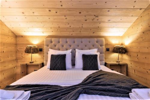 um quarto com uma cama grande e paredes de madeira em Chalet le Petou em Champéry