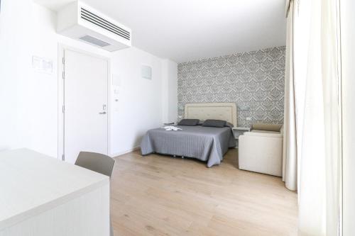 a bedroom with a bed in a white room at Hotel Jesulum in Lido di Jesolo