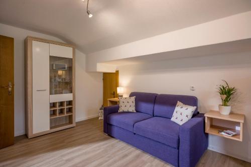a living room with a purple couch and a table at Haus Drei Linden in Going