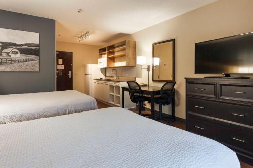 a hotel room with two beds and a desk with a television at Extended Stay America Premier Suites - Nashville - Vanderbilt in Nashville