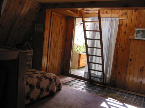 a room with a ladder leading to a door at Flagstaff Chalet in Flagstaff