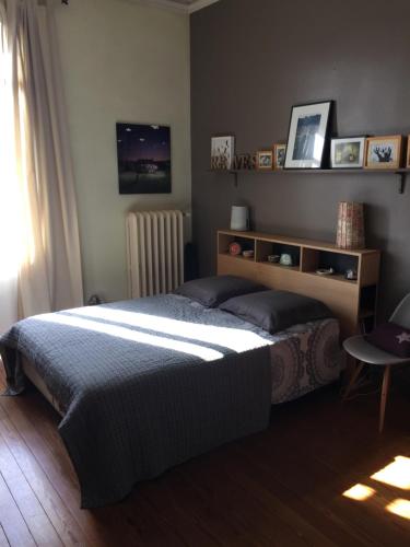 a bedroom with a large bed and a radiator at Au Petit Bonheur in Talence