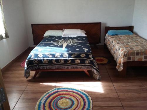 a bedroom with two beds and a rug on the floor at Sítiio São Miguel projeto agroecológico in Caconde