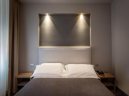 a bed with a silver headboard in a room at HNN Luxury Suites in Genova