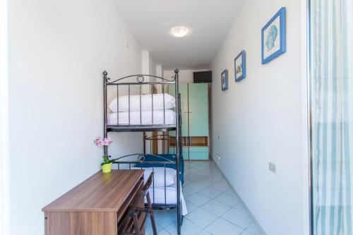 a room with a table and a bunk bed at Residence Kimba in Rimini