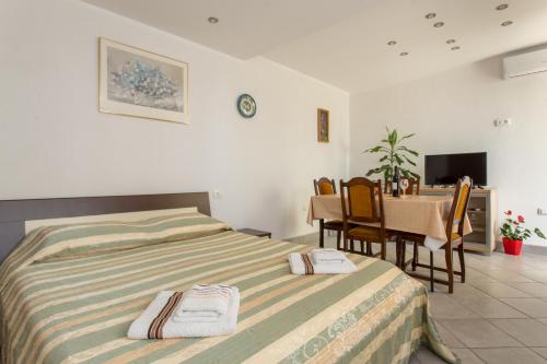 a bedroom with a bed and a table and chairs at Apartment Panorama in Kotor