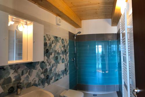 a bathroom with a sink and a shower with blue tiles at Hotel Mojito in Domaso