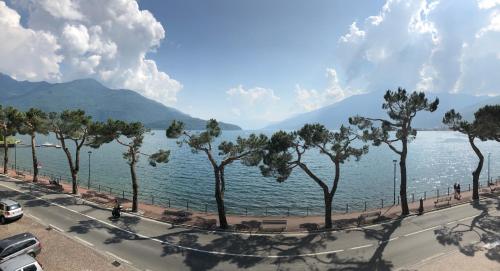 a road next to a body of water with trees at Hotel Mojito in Domaso