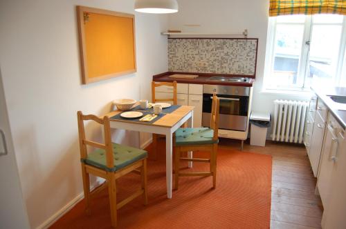 a small kitchen with a table and two chairs at "Über den Dächern" in Malchow