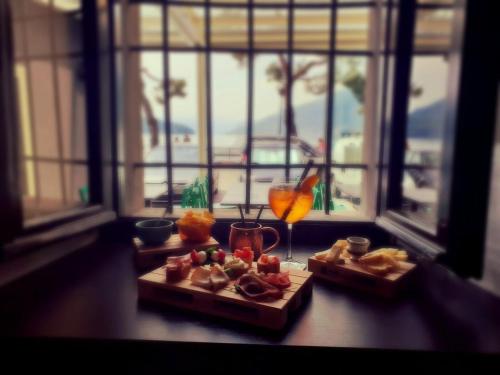 a table with two plates of food and a drink at Hotel Mojito in Domaso