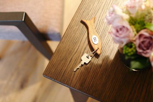 a wooden table with a key and a vase of flowers at Romantik Hotel Kieler Kaufmann in Kiel