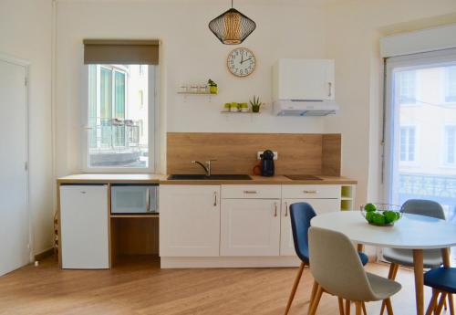 a kitchen with a table and a sink and a table and chairs at Studio Liberté Plein Centre in Saint-Raphaël