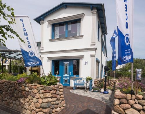 a house with blue doors and flags in front of it at Koserow Ferienwohnung Fam. Jäger 400m zum Strand in Ostseebad Koserow