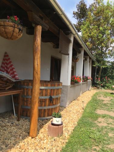 a house with a fence and a porch with flowers at Rózsa Vendégház in Tokaj
