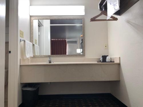 a bathroom with a sink and a mirror at Mid Continent Inn in Greenwood