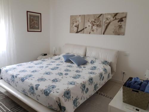 a bedroom with a bed with a blue and white comforter at Le Betulle in Verona