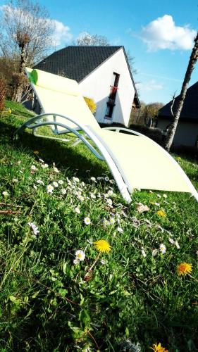 a white object in the grass in front of a house at Rivière & Cottage 4 étoiles en Auvergne - Cantal Auvergne - Valette & Riom in Valette