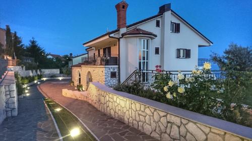 Biały dom z kamienną ścianą obok ulicy w obiekcie Studio Apartment "Brigita" w mieście Rijeka