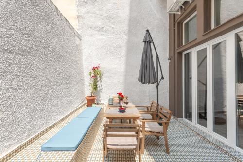 eine Terrasse mit einem Tisch und einem Sonnenschirm in der Unterkunft Downtown Boutique Apartments Acropolis View in Athen