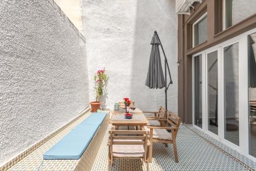 a patio with a table and an umbrella at Downtown Boutique Apartments Acropolis View in Athens