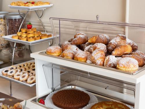 a display case filled with lots of donuts and other pastries at Hotel Nuovo Nord in Genova