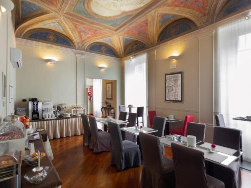 comedor con mesas y sillas y techo en Hotel Nuovo Nord en Génova
