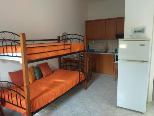 a room with two bunk beds and a kitchen at Reginas Studios in Athéras