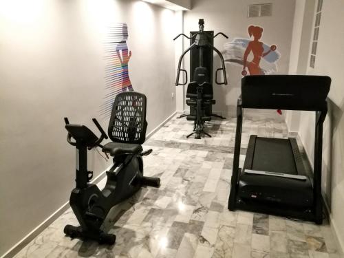 a room with a gym with a treadmill and a camera at Erato Hotel in Agia Marina Aegina