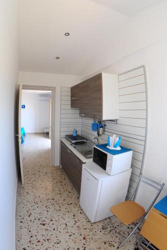 a kitchen with a refrigerator and a microwave at Le Sette Meraviglie in Castellammare del Golfo