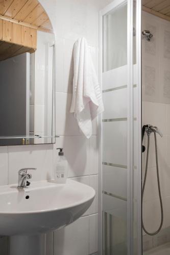 a white bathroom with a sink and a shower at Pension Casa Maruja in Castromayor