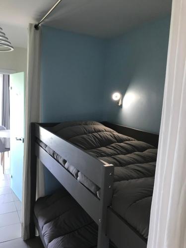 een stapelbed in een slaapkamer met een blauwe muur bij Appartement dans Résidence les Dunes du Golf in Wimereux
