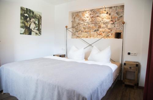 um quarto com uma cama branca e uma parede de pedra em Altstadt Ferienwohnung An Der Stadtmauer em Füssen