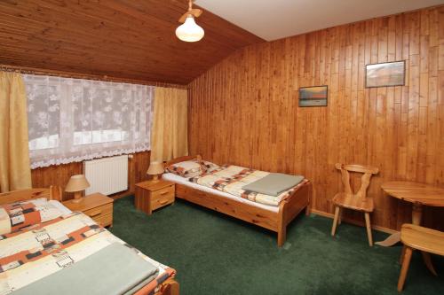 1 dormitorio con 2 camas, mesa y sillas en Pensjonat Hubertus, en Kosewo