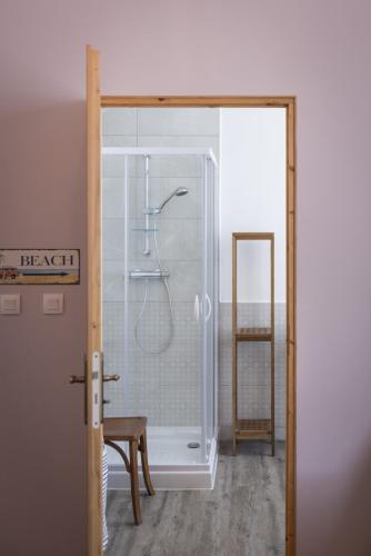 une salle de bain avec une douche avec une porte vitrée dans l'établissement Comme à la Breizhon, à Penmarcʼh