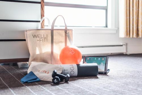 a bag on the floor with a cell phone and a ball at Dossier in Portland