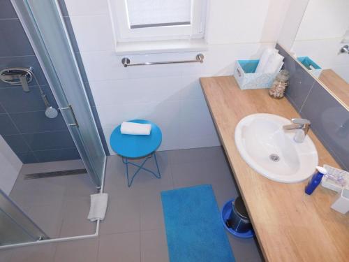 a bathroom with a sink and a blue stool at Apartman Karmen in Tučepi