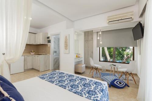 a bedroom with a bed and a table and a kitchen at Lyristis Dinos Studios & Apartments in Faliraki